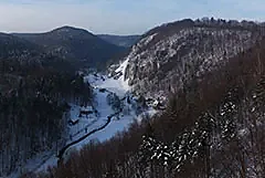 Zimowa panorama Ojcowa z wapiennymi skałami i zabudową w dolinie